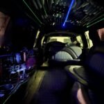 Rear-to-front view of SUV limo showing multiple seating zones and ceiling light display.