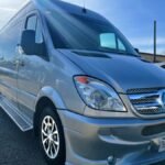 Front angle of silver 15-passenger Mercedes party van with chrome grille – Brantford Limo.