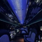 Ceiling view of a luxury SUV limo with fiber optic lighting and mirrored panels, creating a galaxy-like ambiance above black leather seating.