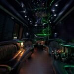 Night-lit interior of 25-passenger party bus with glowing green lights and leather seating – Brantford Limo.