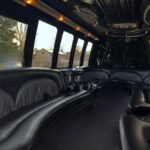 Daylight view inside 25-passenger party bus with curved black leather seats and panoramic windows – Brantford Limo.