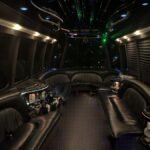 Dimly lit interior of 25-passenger party bus with bar setups and LED ceiling lights – Brantford Limo.
