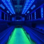 Blue-themed LED party bus interior with green floor lighting – Brantford Limo.
