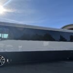 Side profile of 38-passenger white and black party bus under the sun – Brantford Limo.