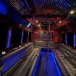 Luxury interior of 38-passenger party limo bus with leather seating, LED ceiling, and dance pole – Brantford Limo.